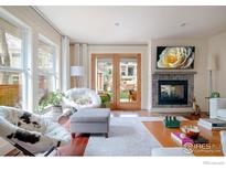 Cozy living room featuring hardwood floors, fireplace, and view to outdoors at 3265 6Th St, Boulder, CO 80304