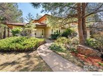 Inviting home with a manicured lawn, mature trees and attractive landscaping enhancing the curb appeal at 4062 Pinon Dr, Boulder, CO 80303