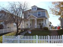 Charming two-story home featuring a welcoming front porch and well-maintained lawn with a white picket fence at 5735 Russell Cir, Frederick, CO 80504