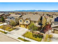 Beautiful two-story home featuring a well-manicured lawn and scenic mountain views at 630 Benton Ln, Erie, CO 80516
