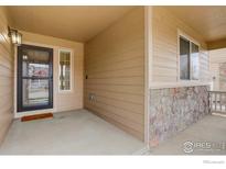 Covered porch featuring stone accents and a window that provides natural light and curb appeal at 1540 Murrlet St, Berthoud, CO 80513