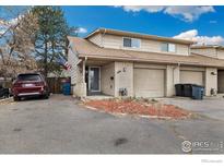 Charming townhome featuring an attached garage, brick facade, and well-kept front yard at 1561 S Sheridan Blvd, Lakewood, CO 80232