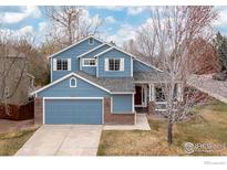 Charming two-story blue home with a well-maintained lawn and attached garage, perfect for suburban living at 1898 Wilson Cir, Erie, CO 80516