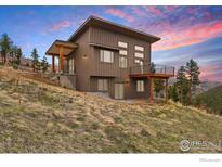 Modern home featuring a sleek, flat roof and contemporary design with hillside setting at 450 Melvina Hill Rd, Boulder, CO 80302
