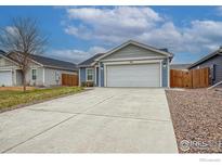 Charming single-story home featuring a spacious driveway and an attached two-car garage at 702 S Fulton Ave, Fort Lupton, CO 80621