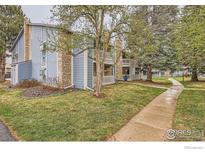 A lovely, well-maintained apartment building with stone accents and mature trees around the property at 8335 Fairmount Dr # 207, Denver, CO 80247