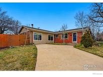 Charming single-story home with a spacious front yard, long driveway, and a mix of brick and siding exterior at 1185 W Midway Blvd, Broomfield, CO 80020