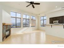 Bright living room with modern fireplace, hardwood floors, and large windows offering ample natural light at 1200 Yarmouth Ave # 239, Boulder, CO 80304