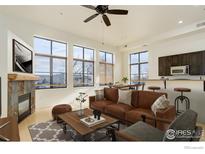 Bright living room with fireplace, leather sofa, and large windows at 1200 Yarmouth Ave # 239, Boulder, CO 80304