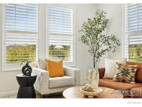 Bright living room featuring large windows, a comfortable seating arrangement, and stylish decor at 1365 Shale Dr, Erie, CO 80516