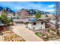 Charming two-story home featuring a front porch with white Adirondack chairs and mountain views at 1525 Judson Dr, Boulder, CO 80305