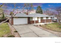 Charming brick and green home with a two-car garage and well-maintained front yard and driveway at 16 Texas Ln, Longmont, CO 80501