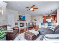 Inviting living room with fireplace, hardwood floors, and stylish furniture at 16022 W 63Rd Ln # A, Arvada, CO 80403