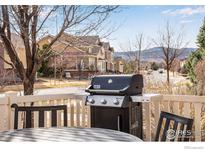 Outdoor grill with table and chairs on a patio area with a view of neighborhood homes at 16022 W 63Rd Ln # A, Arvada, CO 80403
