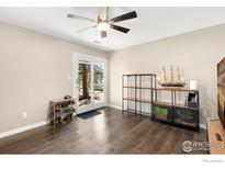 Bright living room features modern ceiling fan, wood floors, and a sliding glass door to the outside at 1607 Cottonwood Dr # 14, Louisville, CO 80027