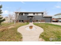 Charming two-story home featuring a well-manicured lawn, gray siding and an inviting circular walkway at 1622 Quivira Dr, Denver, CO 80229