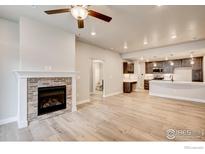 Spacious living room featuring fireplace, wood floors, and modern open floor plan at 235 High Point Dr # 102, Longmont, CO 80504