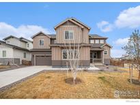 Charming two-story home with a well-maintained lawn, neutral colored siding and an attached garage at 313 Orion Cir, Erie, CO 80516