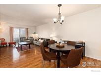 Inviting living room boasts hardwood floors and a comfortable seating area with a sliding glass door to the outside at 3250 Oneal Cir # H17, Boulder, CO 80301