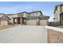Charming two-story home featuring a three-car garage and a welcoming brick-accented front porch at 4426 Sidewinder Loop, Castle Rock, CO 80108