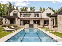 Stunning backyard features a long, modern pool with lounge chairs and manicured lawn at 706 Juniper Ave, Boulder, CO 80304