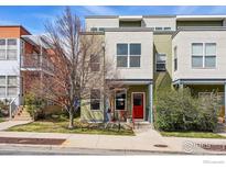 Three-story townhome with a red front door and small porch area with a red chair and table at 1351 Yellow Pine Ave, Boulder, CO 80304