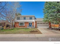 Inviting two-story home featuring a well-manicured lawn and two-car garage at 1449 Adams Pl, Louisville, CO 80027