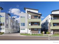 Modern multi-story home featuring a gray, green, and brick exterior at 1615 Harlan St # 2, Lakewood, CO 80214