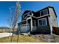 Charming two-story home with a three-car garage, stone accents, and a covered front porch in a well-kept neighborhood at 1800 Vantage Pkwy, Berthoud, CO 80513