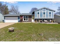 Charming blue two-story home with an attached garage and front lawn at 205 Lucerne Dr, Lafayette, CO 80026