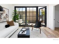 Bright living room with large sliding glass doors opening to a private patio, modern furniture, and light wood flooring at 2118 Pearl St # C, Boulder, CO 80302