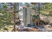 Charming exterior view of a multi-story home with tiered stone-walled garden and mature trees at 287 Brook Cir, Boulder, CO 80302