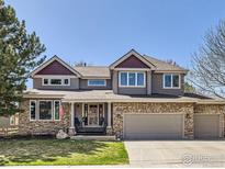 Charming two-story home with stone accents, well-manicured lawn and a welcoming front porch at 308 Elk Trl, Lafayette, CO 80026