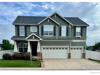 Two-story home with a three-car garage, well-maintained lawn, and beautiful landscaping at 5861 Mt Shadows Blvd, Firestone, CO 80504