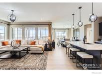 Bright open-concept living area with a modern kitchen, dining area, and comfortable seating space at 600 Grenville Cir, Erie, CO 80516