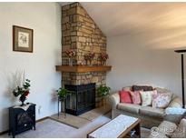 Inviting living room showcases a stone fireplace and comfortable seating area with decorative pillows at 6239 Willow Ln, Boulder, CO 80301