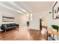 Bright living room features hardwood floors, neutral walls, and seamless access to dining and kitchen at 6396 Twin Lakes Rd, Boulder, CO 80301