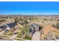 Wide aerial view of a residential community with snow-capped mountains in the distance at 6433 Eagle Butte Ave, Frederick, CO 80516