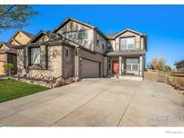 Charming two-story home featuring a brick facade, covered porch, and attached two-car garage with a concrete driveway at 6433 Eagle Butte Ave, Frederick, CO 80516