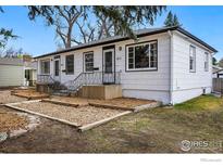 Charming home with updated landscaping, a cozy porch, and visible house numbers at 809 Sunset St, Longmont, CO 80501