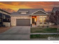 Charming single-Gathering home featuring brick accents, a two-car garage, and manicured lawn at 125 Indian Peaks Dr, Erie, CO 80516