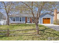 Charming home with well-maintained lawn, mature trees, brick accents, and wooden garage door at 1529 Washington Ave, Louisville, CO 80027