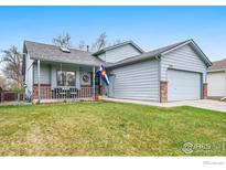 Charming home with a well-manicured lawn, cozy front porch, and attached two-car garage, showcasing curb appeal at 1731 Sumner St, Longmont, CO 80501