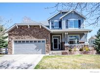 Charming two-story home featuring a stone facade, blue siding, and a well-manicured front yard at 1867 W 131St Ln, Denver, CO 80234