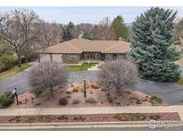 Lovely brick home with mature landscaping including garden beds and trees in a desirable location at 2205 Lake Park Dr, Longmont, CO 80503