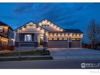 Charming home featuring a three-car garage, lovely front porch, and manicured lawn at 441 Dusk Pl, Erie, CO 80516