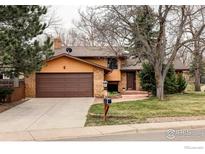Charming two-story home with brick facade, mature trees and well-maintained landscaping at 590 Yuma Cir, Boulder, CO 80303