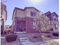 Charming two-story home with a well-manicured lawn and a blossoming tree in the front yard at 61 Avocet Ct, Longmont, CO 80501