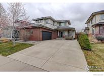 Charming two-story home featuring a brick facade, attached garage, and a well-manicured front yard at 637 Millet Cir, Brighton, CO 80601
