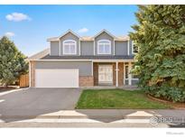 Charming two-story home with a well-manicured lawn, attached garage, and classic architectural details on a sunny day at 10894 Depew Pl, Westminster, CO 80020